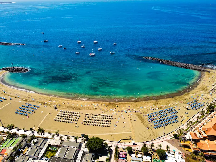 Calm turquoise water and sunbeds on Los Cristianos Beach