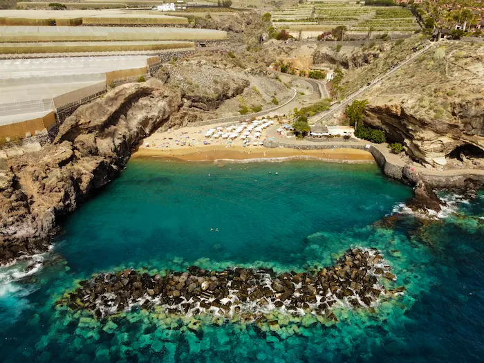 Playa Abama natural bay surrounded by rocks and green-blue sea water