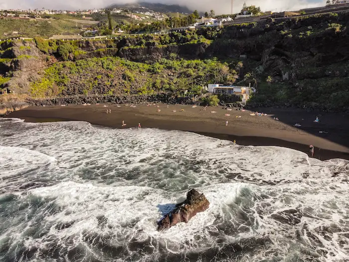 Rocky outcrop at El Bollullo Beach in the middle of strong waves