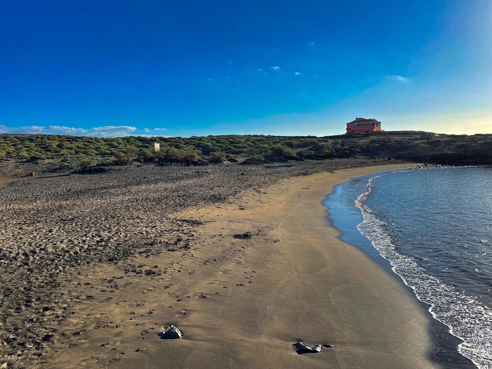 Sandy stretch of Abades Beach Tenerife with old military bunker in the background.