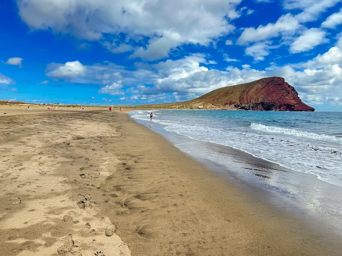 Shoreline of La Tejita Beach with soft waves and Montaña Roja in view