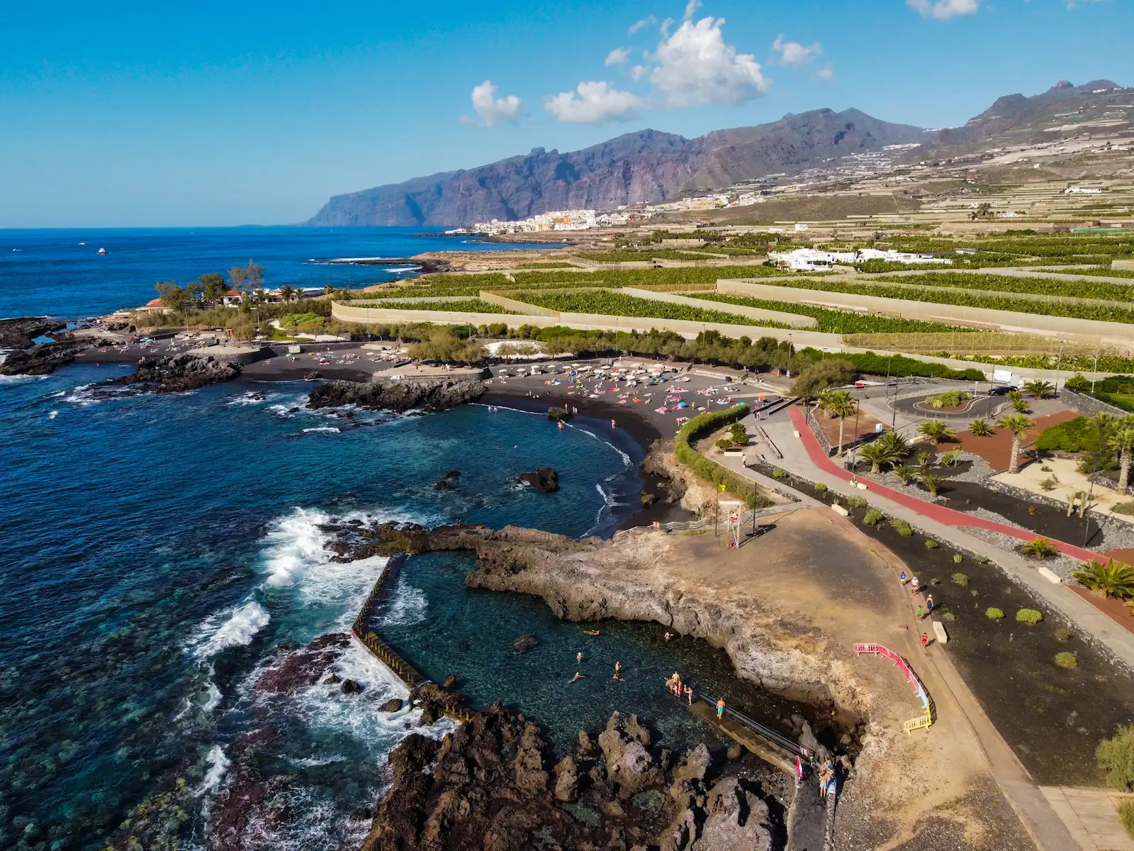 Drone view of the natural pool in Alcalá Tenerife with volcanic rocks and ocean waves