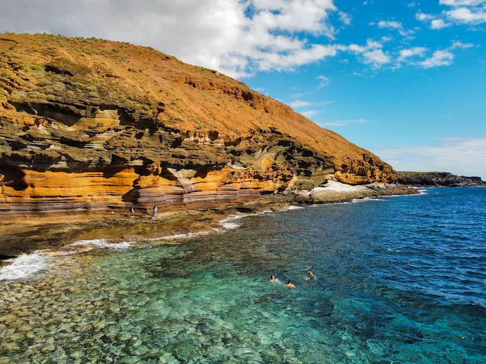 Clear water and volcanic coastline at Playa Montaña Amarilla Tenerife