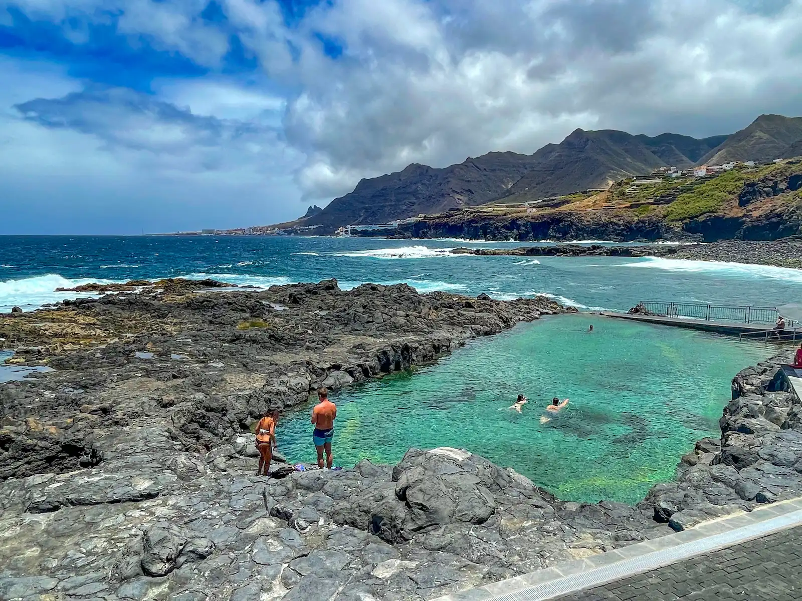 People swimming in Jover’s natural pool with kids playing nearby