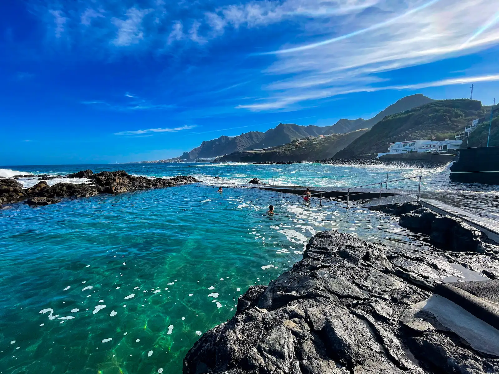 Clear turquoise water at Jover natural pool with cliffs in the background