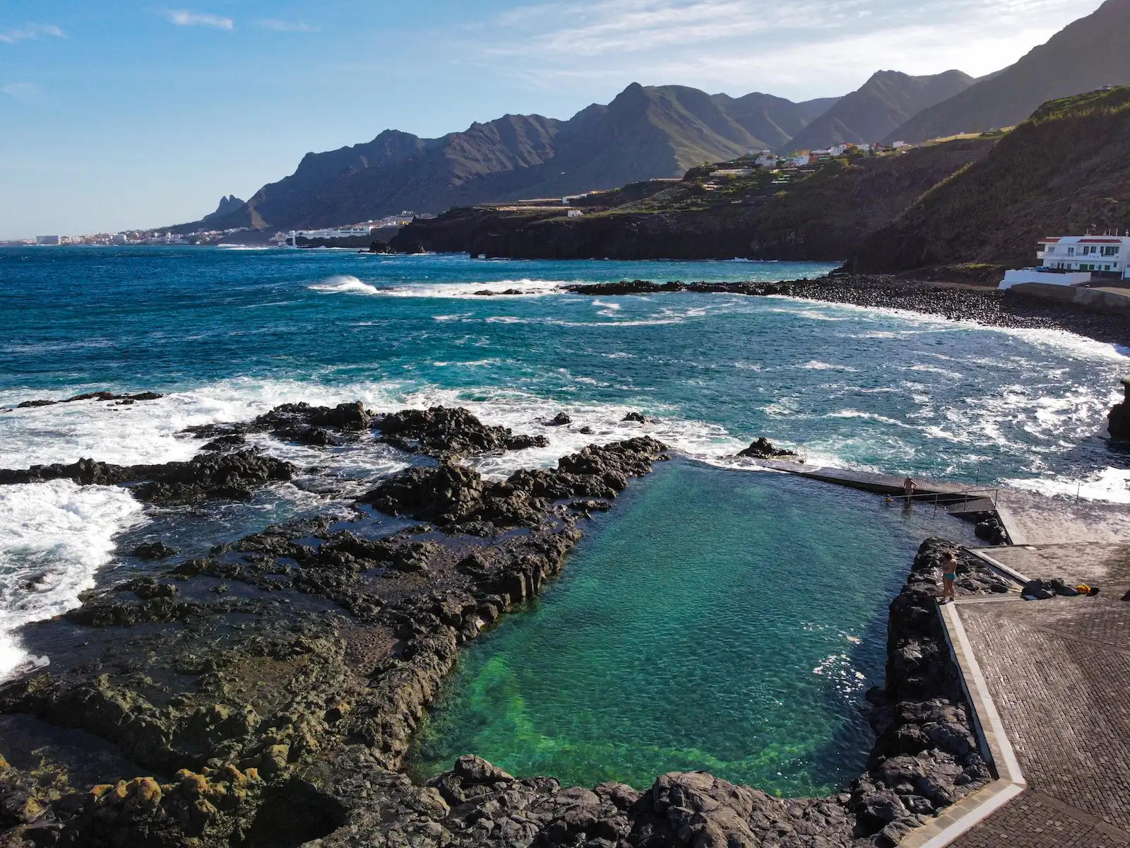 Clear and empty natural pool at Jover, surrounded by volcanic rocks