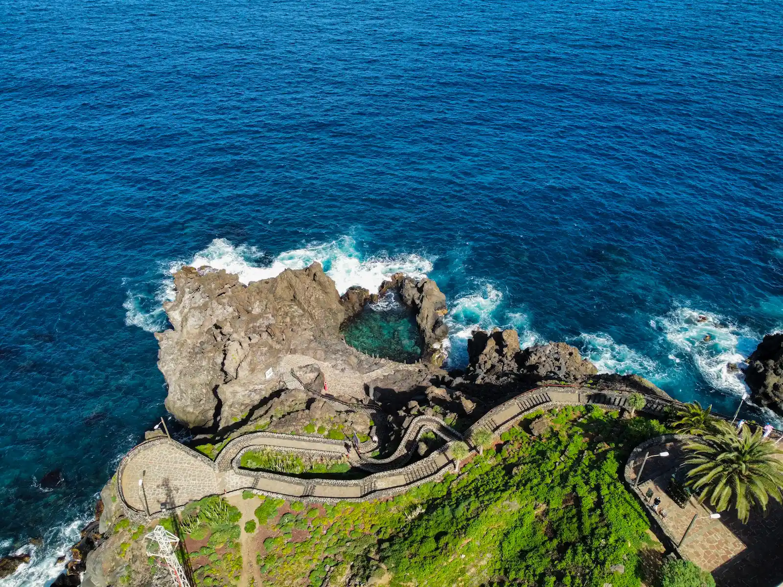 Aerial view of Charco de La Laja with rugged cliffs and waves in north Tenerife