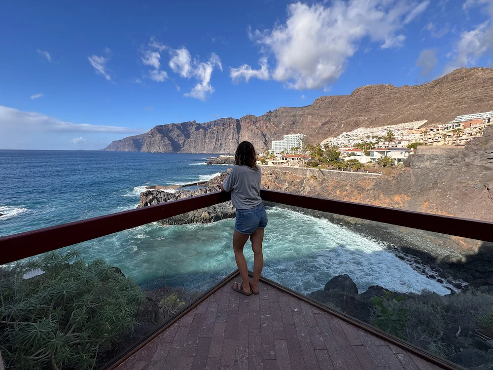Woman looking at Los Gigantes cliffs from a wooden viewpoint