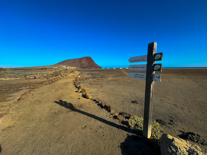 Hiking trail signpost pointing toward Montaña Roja and El Médano