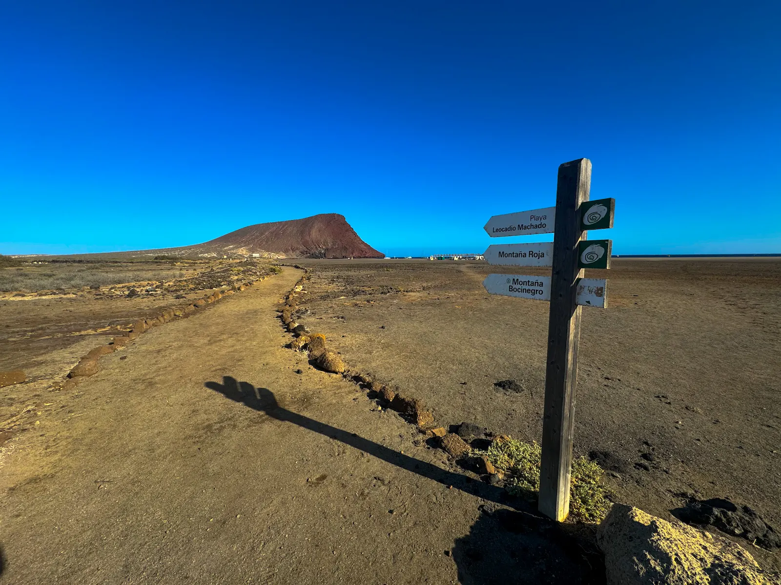 Hiking trail signpost pointing toward Montaña Roja and El Médano
