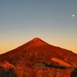 Mount Teide glowing at sunset with moon in the sky