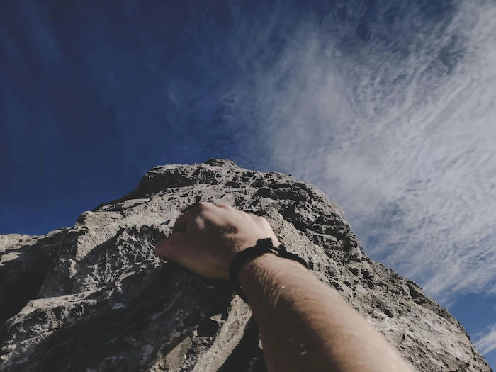 Rock climber gripping volcanic cliff in Tenerife