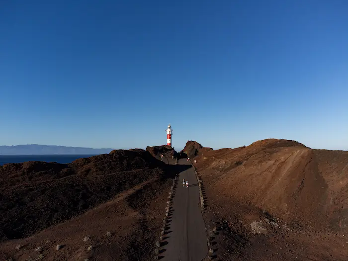 Red and white lighthouse at Faro de Punta de Teno with volcanic landscape and ocean view, Tenerife
