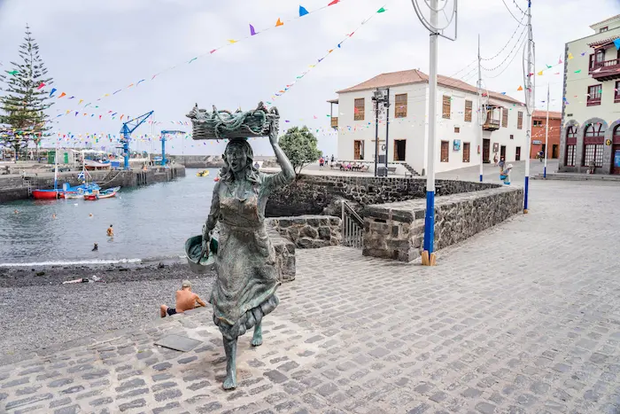 Statue of a Canarian woman with fish basket at the harbor in Puerto de la Cruz, Tenerife