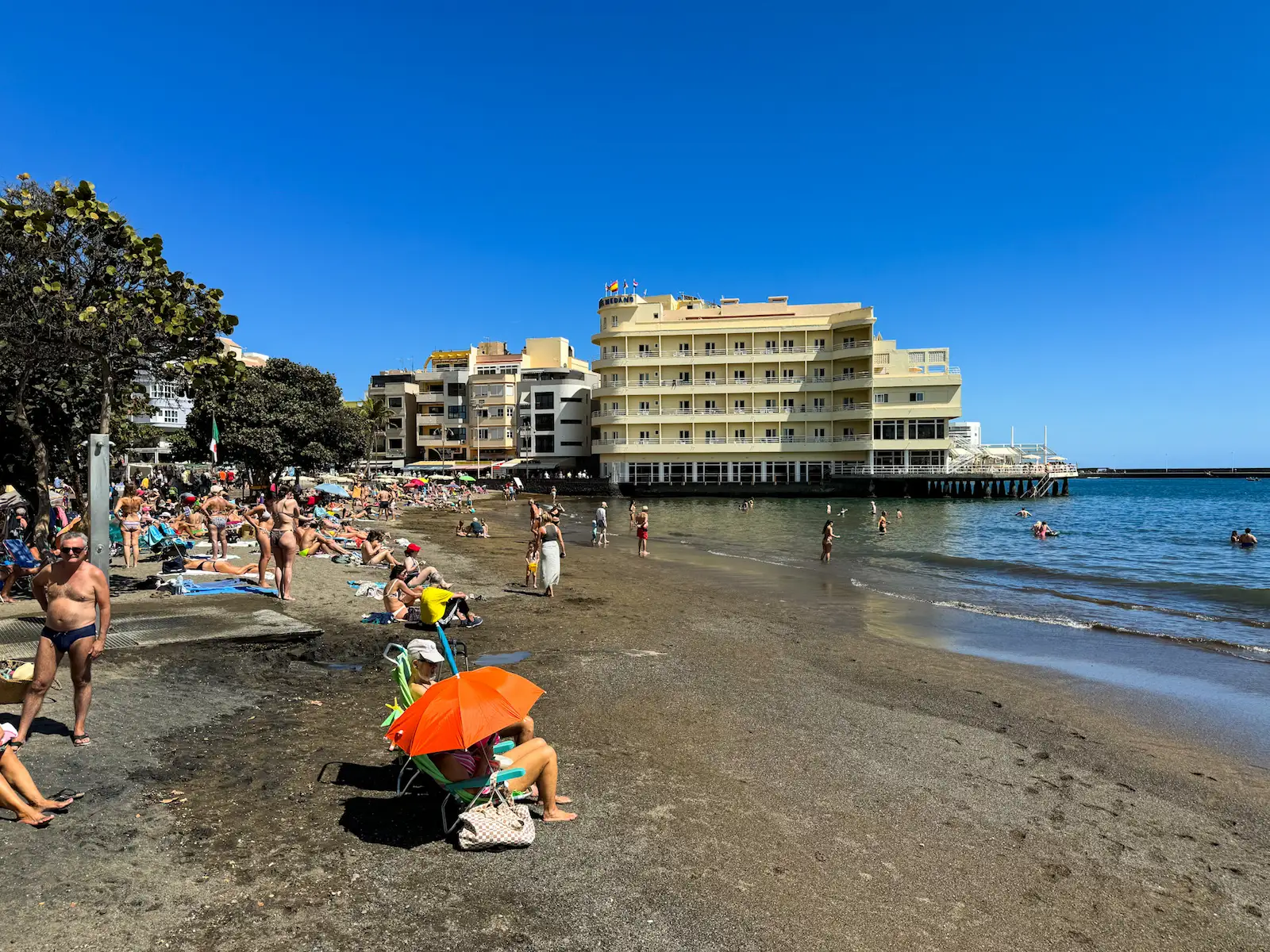 El Médano town beach with families relaxing near the waterfront buildings