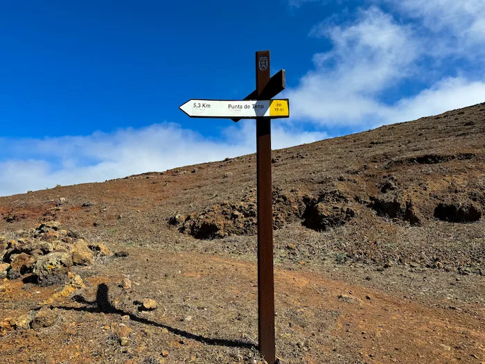 Hiking trail signpost pointing to Punta de Teno on a volcanic path
