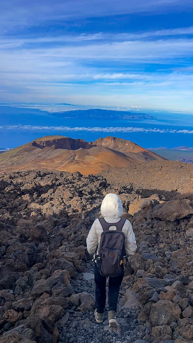 Hiker on trail near Teide Peak with view of Pico Viejo crater, Tenerife